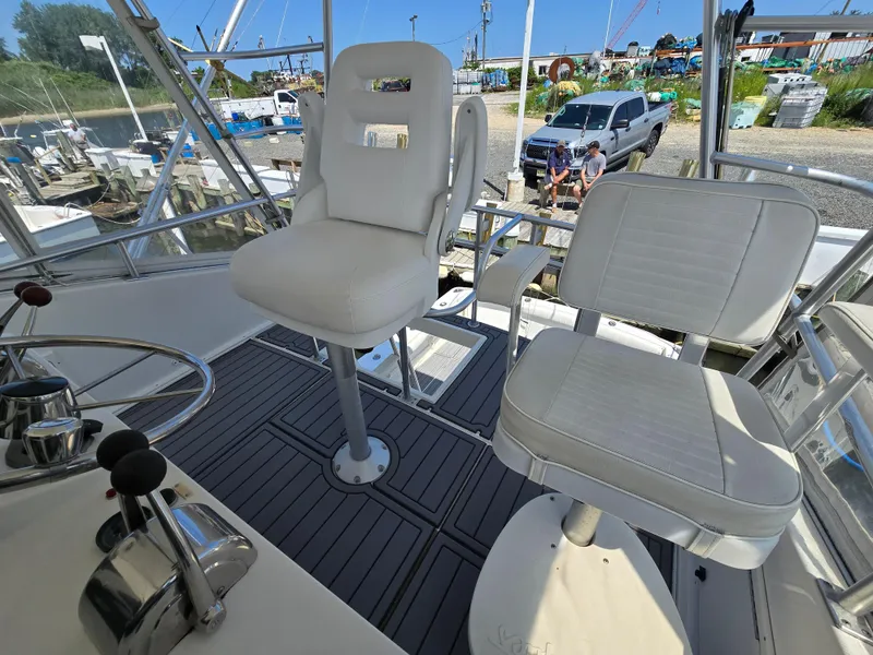 Slide: The Image of Helm seating on 1998 Henriques 38 Sportfisherman, featuring white captain chairs and controls. - 20