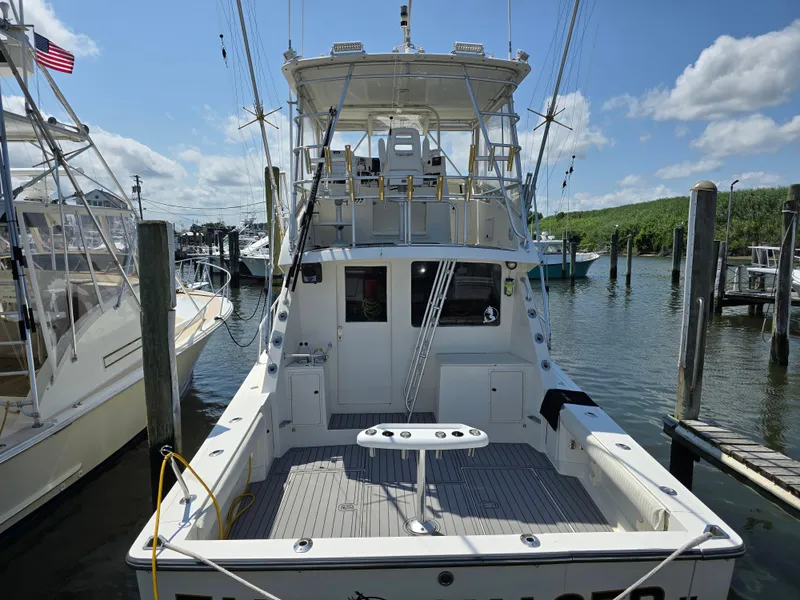Slide: The Image of 1998 Henriques 38 Sportfisherman docked, featuring spacious deck and fishing equipment. - 3