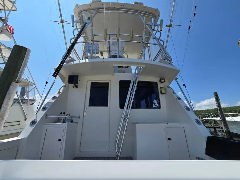 Slide: The Image of 1998 Henriques 38 Sportfisherman boat with tower and fishing equipment under clear blue sky. - 5