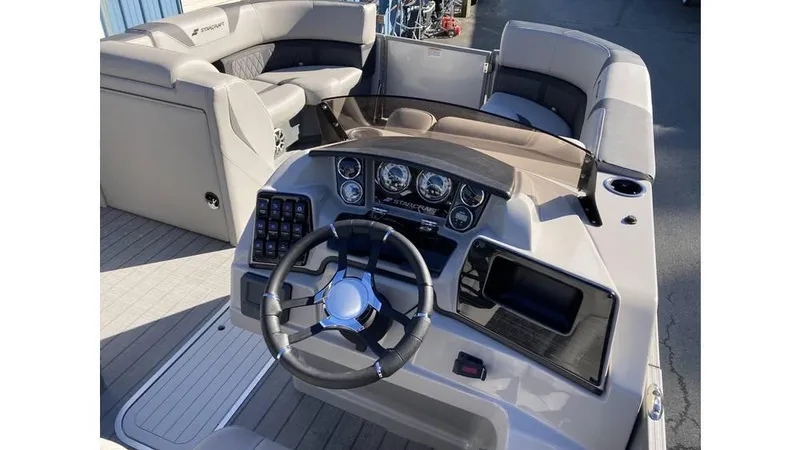 Slide: The Image of 2025 Starcraft CX 23 RL boat interior with steering wheel and seating area. - 8