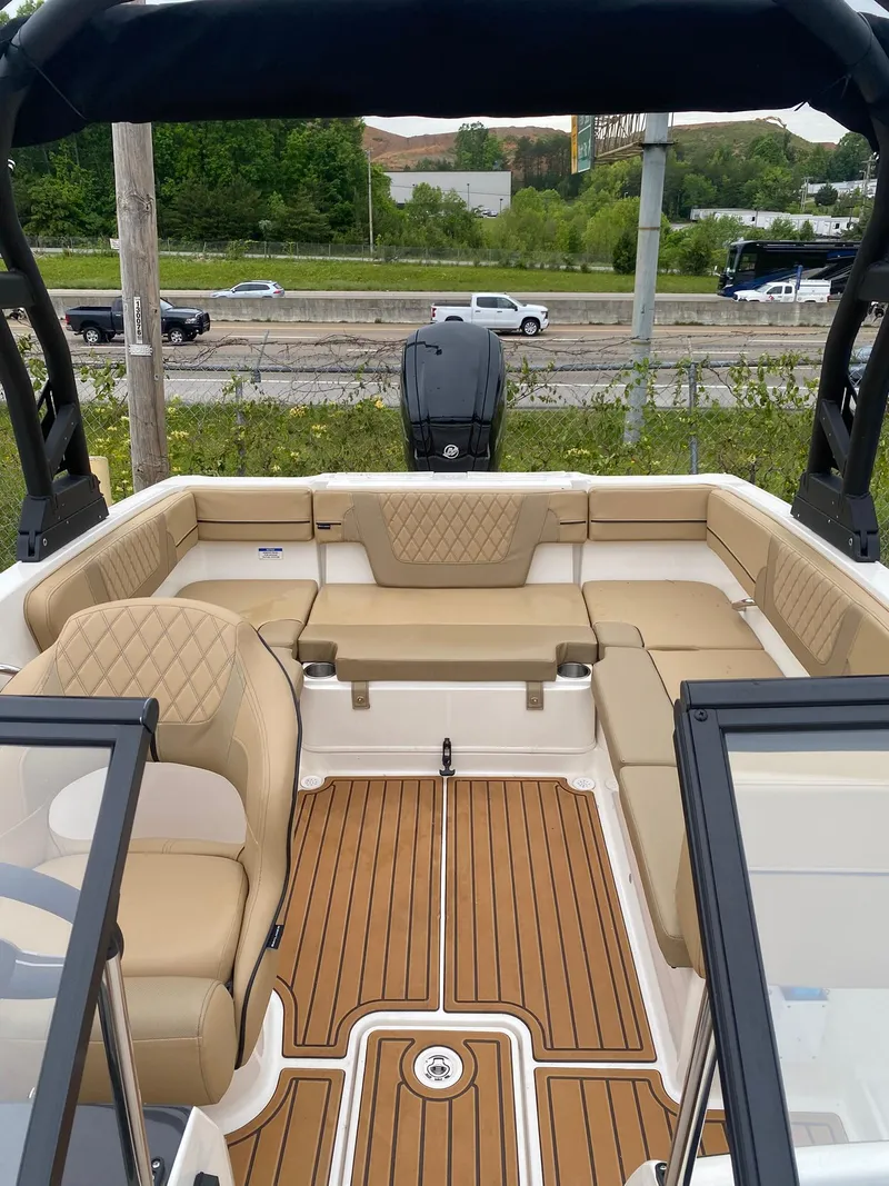 Slide: The Image of 2025 Bayliner VR4 Bowrider OB interior with tan seating and wood-style flooring. - 10