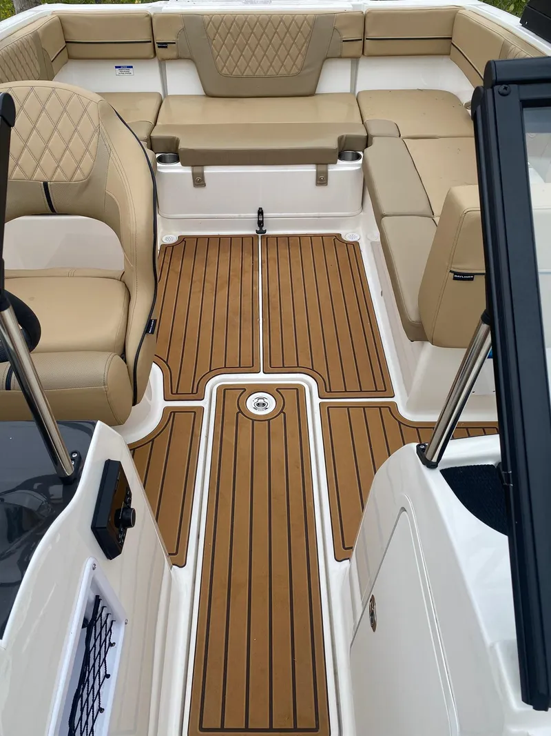 Slide: The Image of 2025 Bayliner VR4 Bowrider OB interior with tan seating and teak-style flooring. - 11