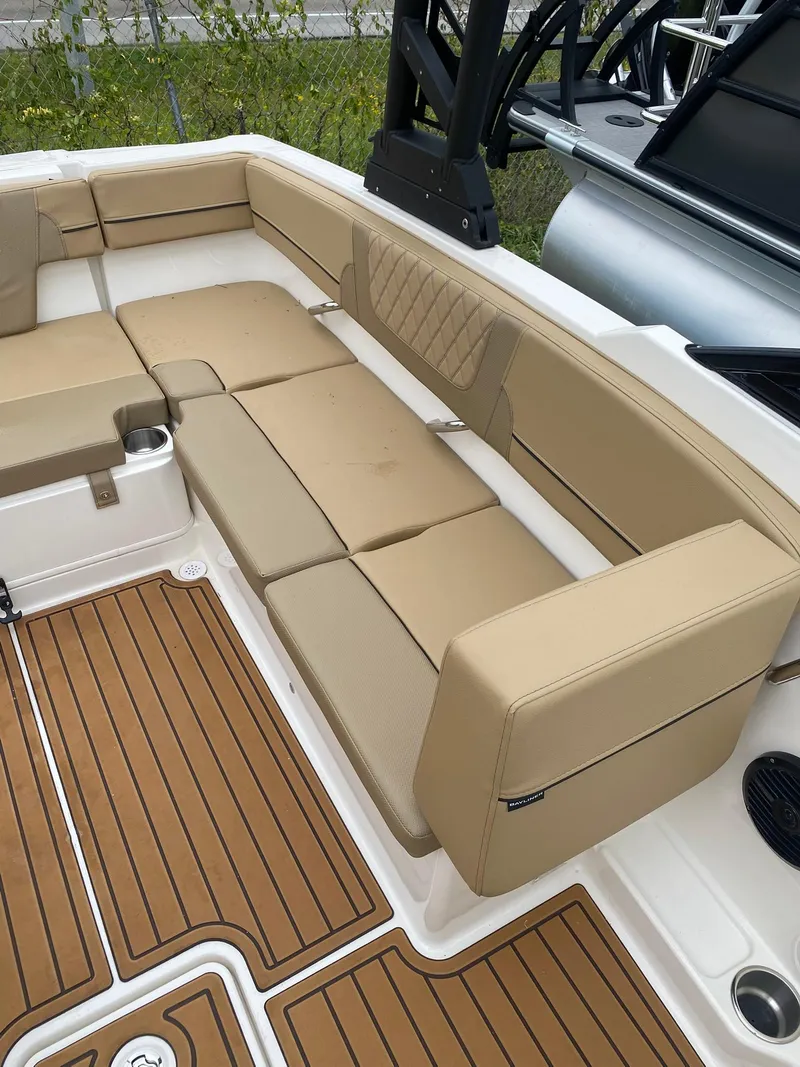 Slide: The Image of 2025 Bayliner VR4 Bowrider OB interior with tan seating and wood-style flooring. - 12