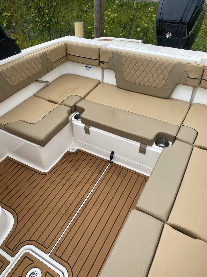 Slide: The Image of 2025 Bayliner VR4 Bowrider OB interior with tan seating and wood-style flooring. - 13