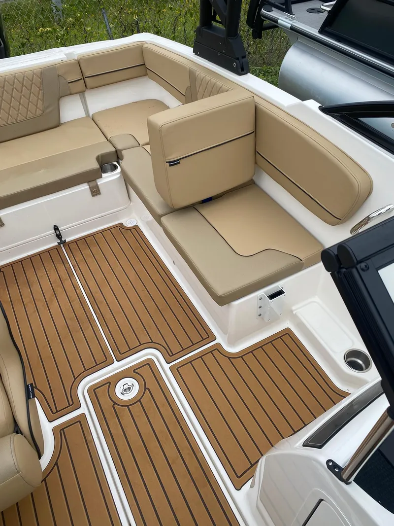 Slide: The Image of 2025 Bayliner VR4 Bowrider OB interior with tan seating and wood-patterned flooring. - 15