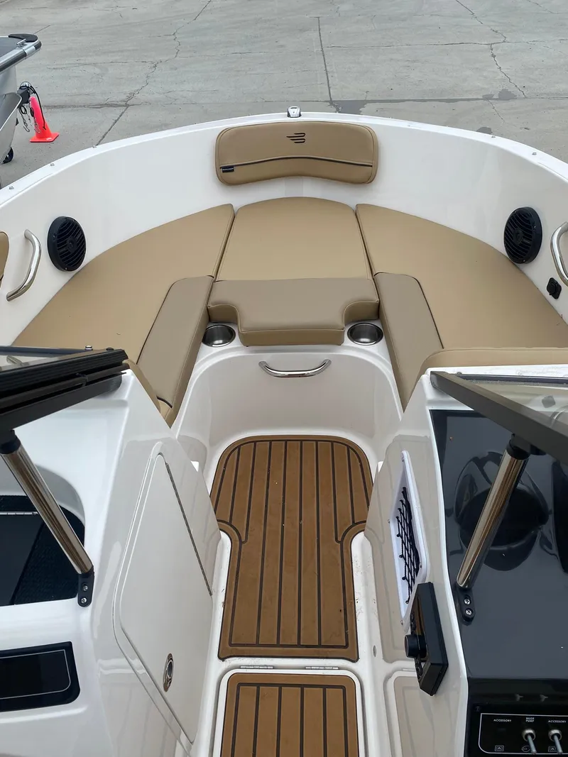 Slide: The Image of 2025 Bayliner VR4 Bowrider OB interior with tan seating and wood-style flooring. - 8
