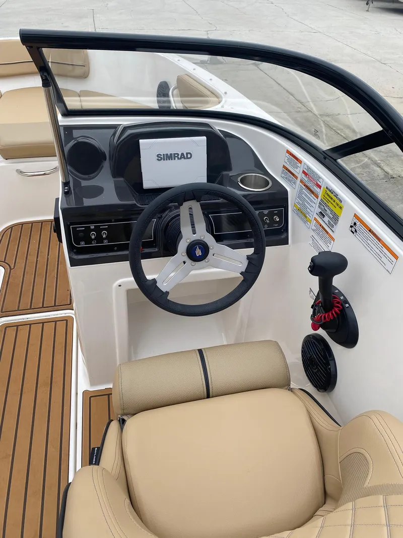 Slide: The Image of 2025 Bayliner VR4 Bowrider OB cockpit with Simrad display and tan seating. - 9