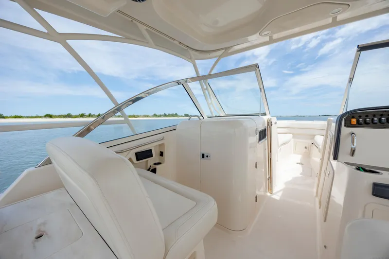 Slide: The Image of 2020 Grady-White Freedom 307 boat interior with seating and dashboard, under clear blue sky. - 14