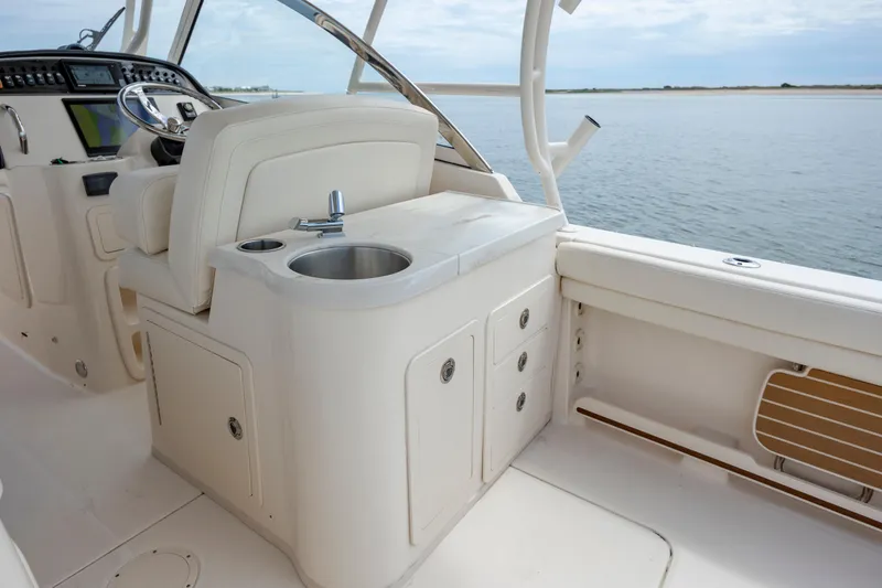 Slide: The Image of 2020 Grady-White Freedom 307 boat interior with helm and sink, overlooking calm waters. - 19