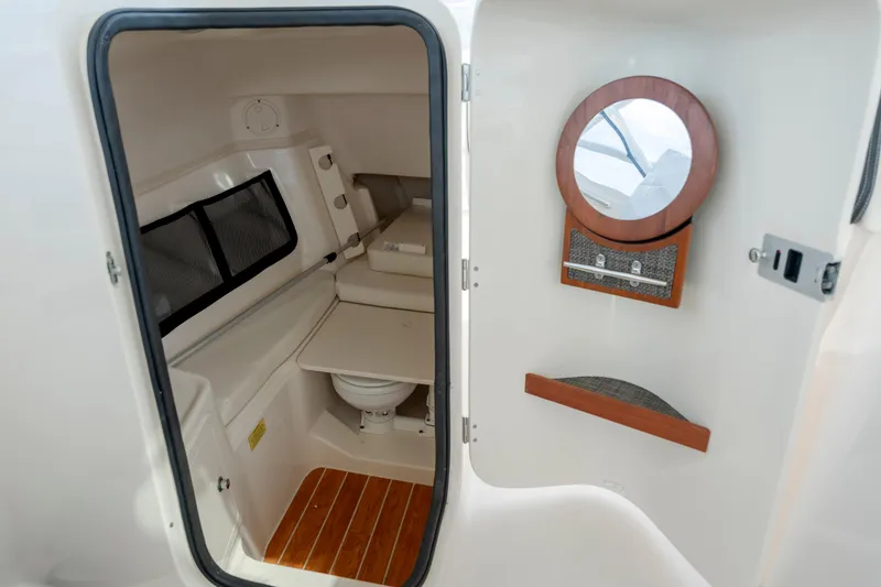 Slide: The Image of 2020 Grady-White Freedom 307 boat cabin interior with wooden flooring and compact amenities. - 23