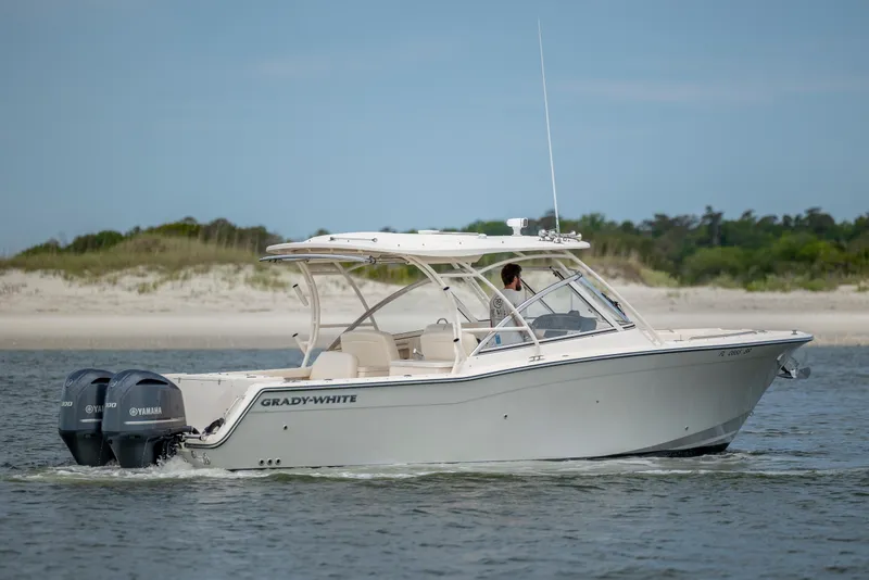 Slide: The Image of 2020 Grady-White Freedom 307 boat cruising near a sandy shoreline. - 3