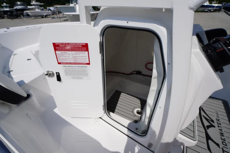 Slide: The Image of 2026 Tidewater 198 CC Adventure boat storage compartment with open door, showcasing interior space. - 19