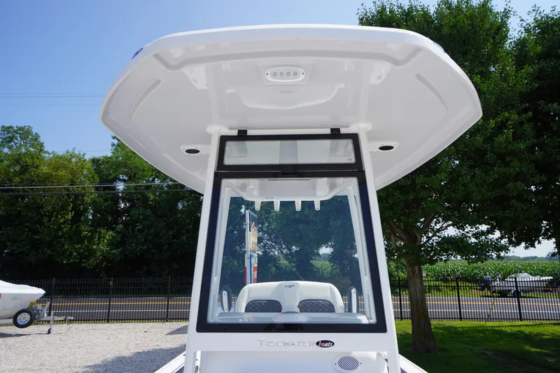 Slide: The Image of 2026 Tidewater 198 CC Adventure boat with T-top, parked outdoors. - 2