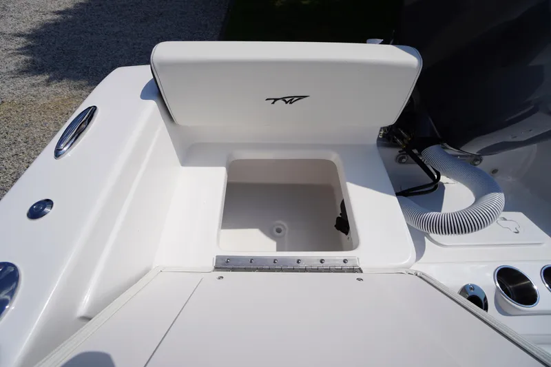 Slide: The Image of 2026 Tidewater 198 CC Adventure boat storage compartment with open lid and cup holders. - 37