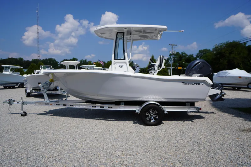 Slide: The Image of 2026 Tidewater 198 CC Adventure boat on trailer, parked outdoors under blue sky. - 56