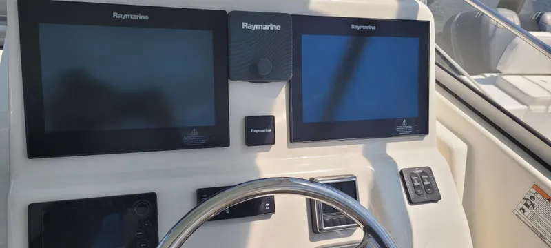 Slide: The Image of Century 30 boat dashboard with Raymarine displays, steering wheel, and control panel, 2015 model. - 15