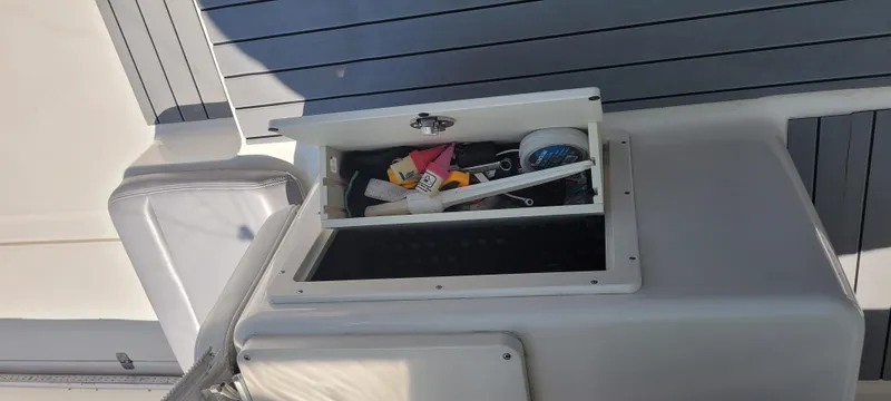 Slide: The Image of Open storage compartment on a 2015 Century 30 boat, containing various tools and accessories. - 19