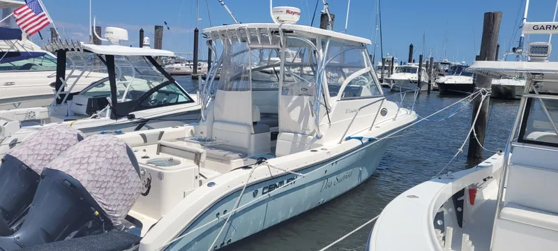 The Image of 2015 Century 30 boat docked at marina, featuring dual outboard motors and sleek design. - 2