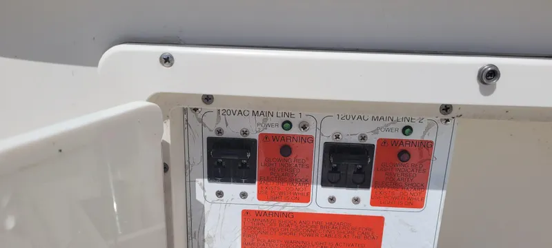 Slide: The Image of Electrical panel with warning labels on a 2015 Century 30 boat. - 24