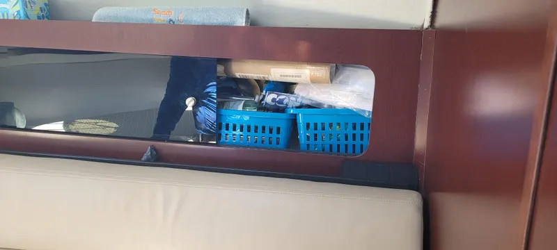 Slide: The Image of Storage compartment in a 2015 Century 30 boat with blue baskets and various items. - 44