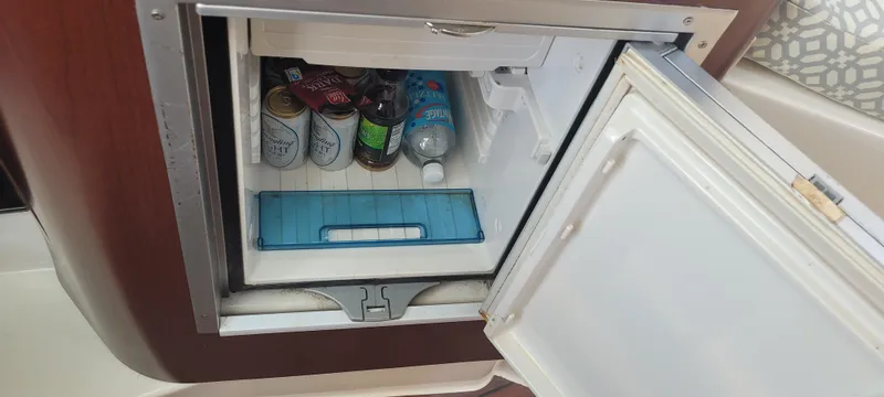 Slide: The Image of Mini fridge on Century 30 boat, stocked with drinks and snacks, open door view. - 48