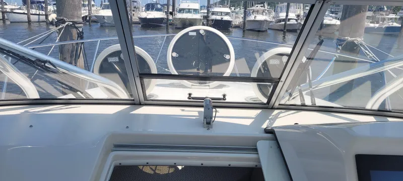 Slide: The Image of 2015 Century 30 boat interior with marina view, featuring a sleek dashboard and windshield. - 21