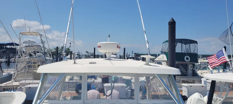 Slide: The Image of 2015 Century 30 boat docked at marina, surrounded by other vessels, clear sky above. - 36