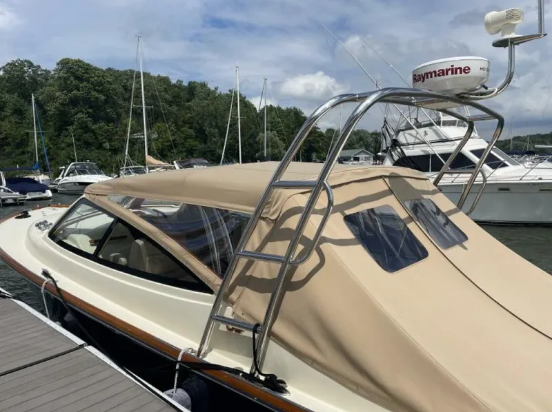 Slide: The Image of 2012 Hinckley Talaria yacht docked, featuring beige canopy and Raymarine radar. - 2