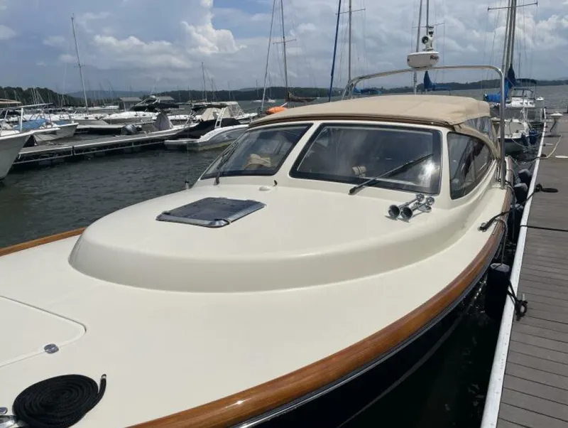 Slide: The Image of 2012 Hinckley Talaria boat docked at marina under cloudy sky. - 3
