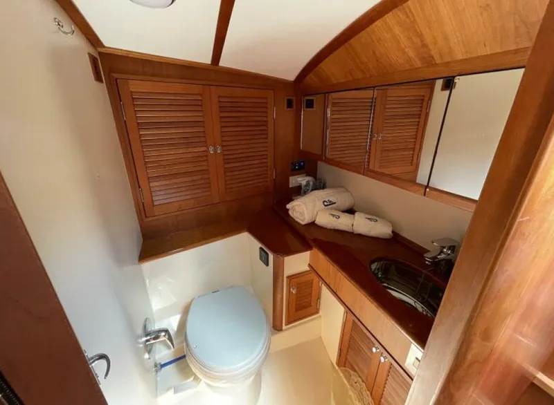 Slide: The Image of Luxurious 2012 Hinckley Talaria yacht bathroom with wooden cabinetry and modern fixtures. - 7