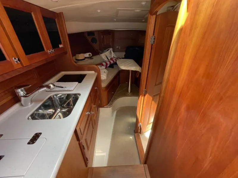 Slide: The Image of Interior of 2012 Hinckley Talaria yacht with wooden cabinetry and compact kitchen area. - 9