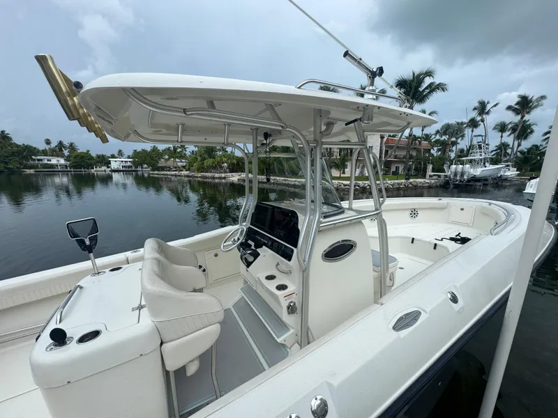 Slide: The Image of 2006 Hydra-Sports Vector 2900 CC boat docked by a serene waterfront with palm trees. - 4