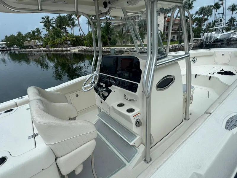 Slide: The Image of 2006 Hydra-Sports Vector 2900 CC boat interior with helm, seats, and controls by a waterfront. - 5