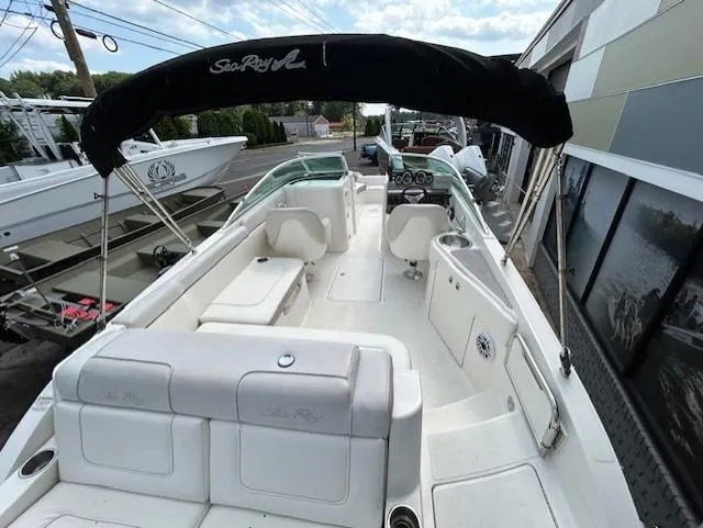 Slide: The Image of 2012 Sea Ray 260 Sundeck boat with spacious seating and canopy, docked at marina. - 10