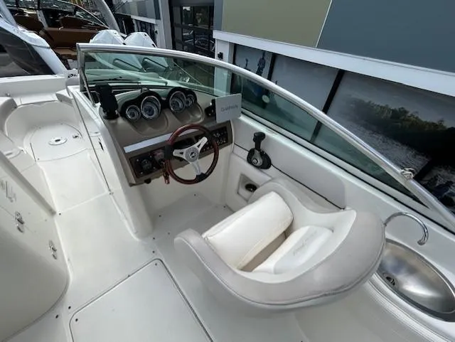 Slide: The Image of 2012 Sea Ray 260 Sundeck cockpit with steering wheel, gauges, and seating. - 11