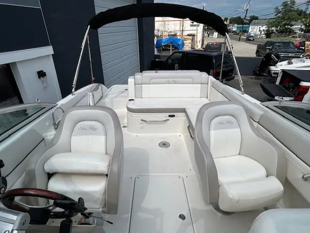 Slide: The Image of 2012 Sea Ray 260 Sundeck boat with white seating and black canopy in a marina setting. - 18