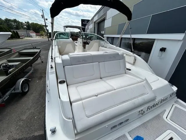 Slide: The Image of 2012 Sea Ray 260 Sundeck boat with white seating, docked outdoors. - 9