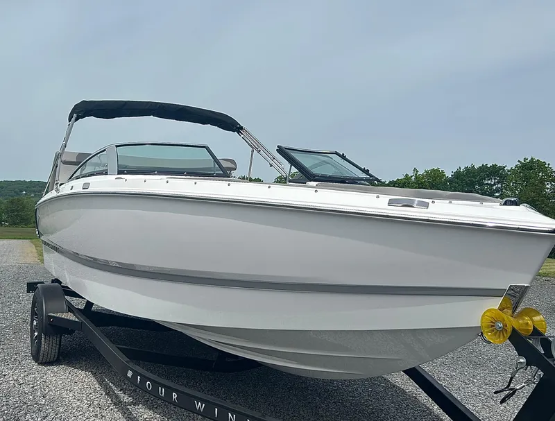 Slide: The Image of 2025 Four Winns H1 Freedom boat on trailer, sleek design, outdoor setting. - 1