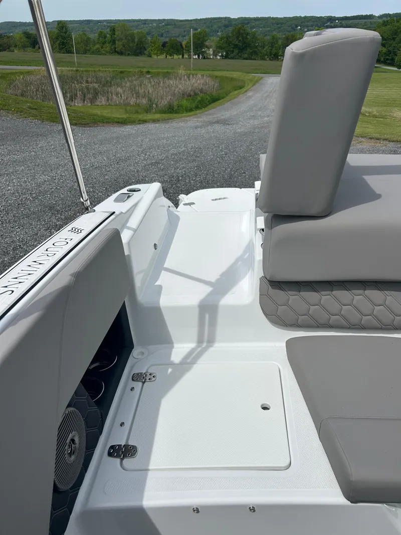 Slide: The Image of 2025 Four Winns H1 Freedom boat interior with gray seating and storage compartment. - 10