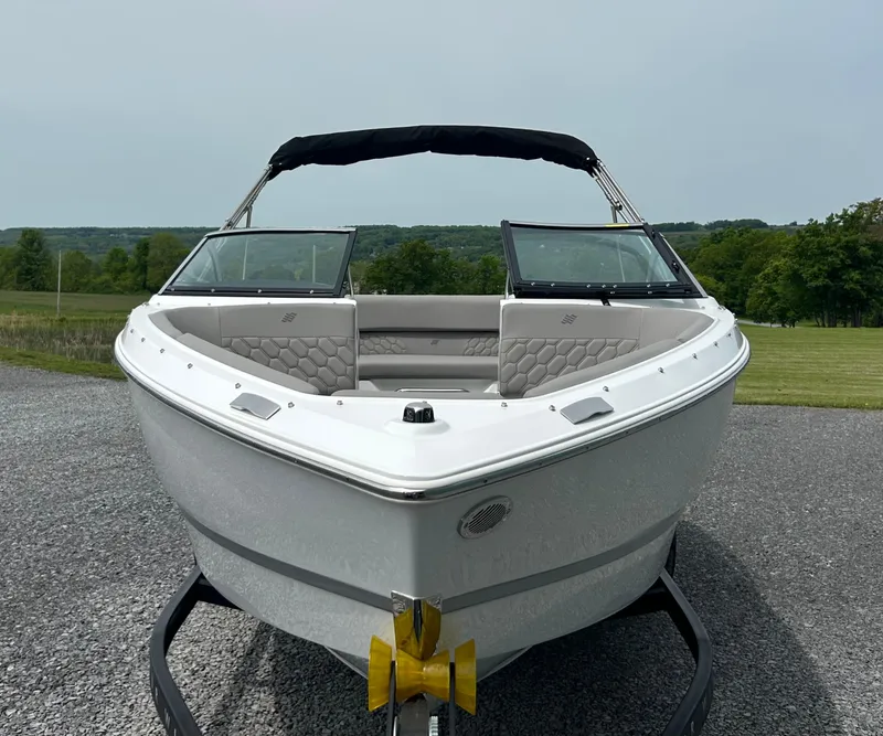 Slide: The Image of 2025 Four Winns H1 Freedom boat on trailer, front view, parked outdoors. - 5