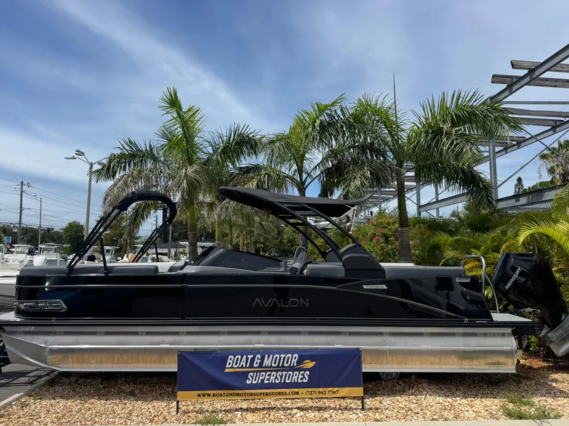 Slide: The Image of 2025 Avalon Catalina Platinum Quad Lounge boat displayed outdoors with palm trees. - 1