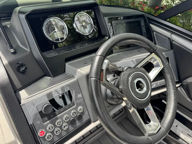 Slide: The Image of Steering console of 2025 Avalon Catalina Platinum Quad Lounge boat, featuring modern controls and gauges. - 25
