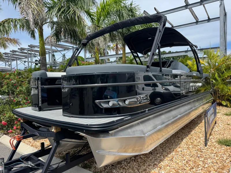 Slide: The Image of 2025 Avalon Catalina Platinum Quad Lounge 27' pontoon boat displayed outdoors with palm trees. - 3