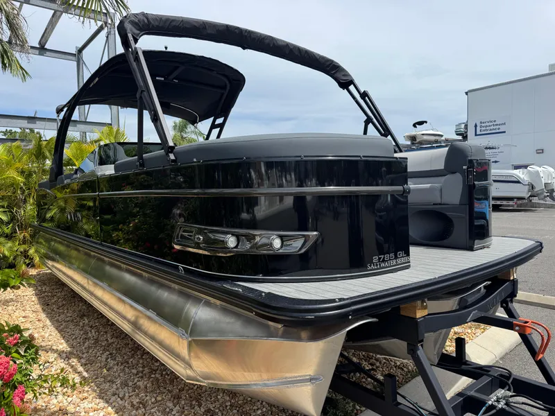 Slide: The Image of 2025 Avalon Catalina Platinum Quad Lounge 27' pontoon boat, black exterior, parked outdoors. - 5