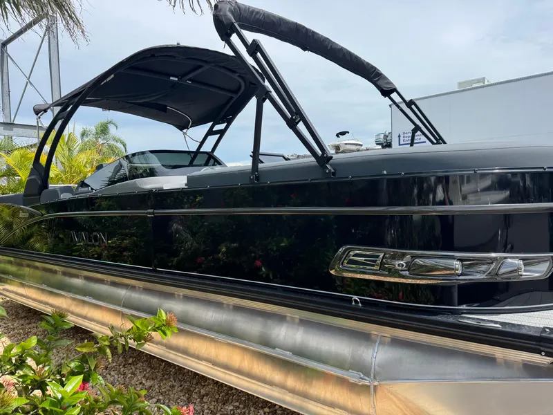 Slide: The Image of 2025 Avalon Catalina Platinum Quad Lounge boat, sleek black design, docked outdoors. - 6