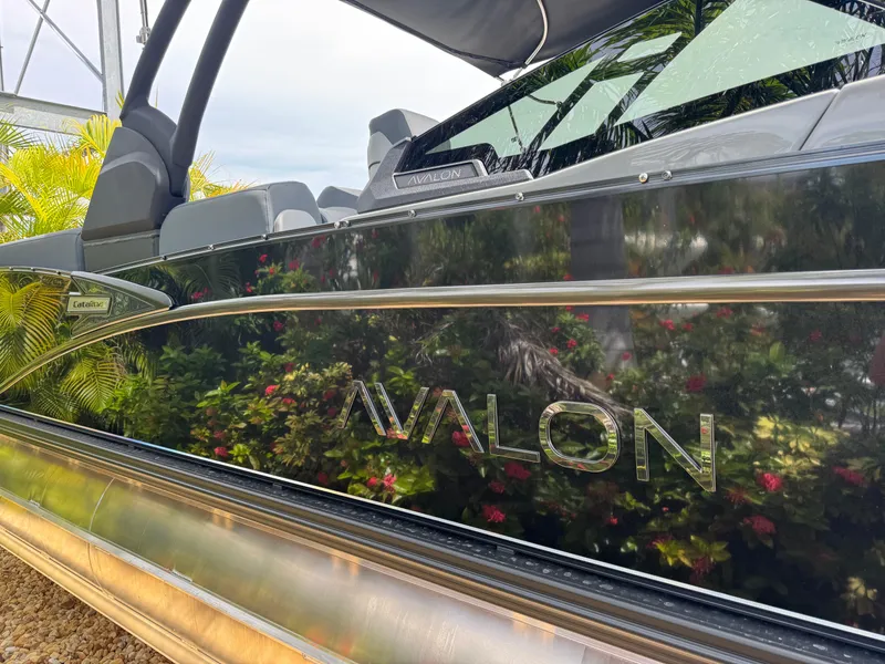 Slide: The Image of 2025 Avalon Catalina Platinum Quad Lounge boat with sleek black exterior and reflective finish. - 7