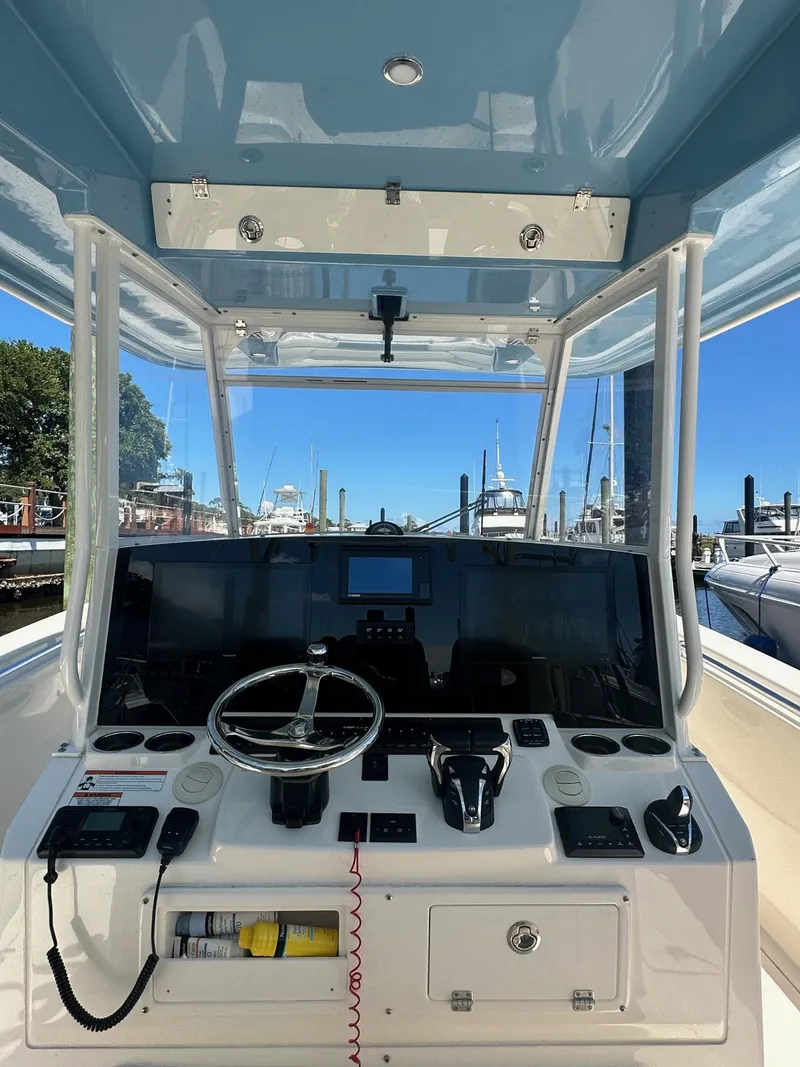 Slide: The Image of 2022 Cobia 350 Center Console boat helm with steering wheel and navigation controls. - 10