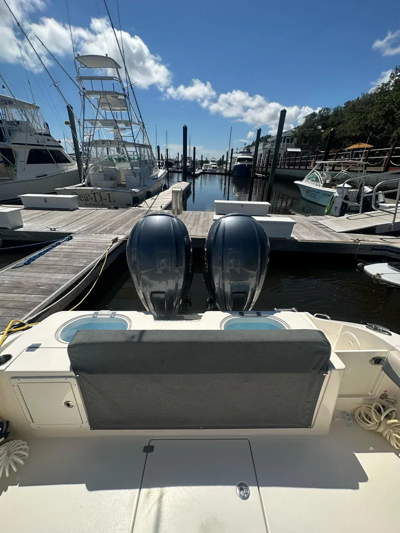 Slide: The Image of 2022 Cobia 350 Center Console boat docked with twin engines, clear sky background. - 13