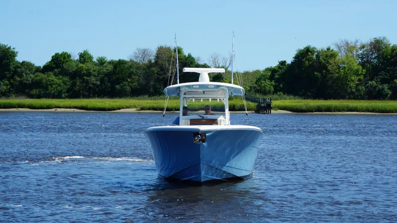 Slide: The Image of 2022 Cobia 350 Center Console boat on a calm river with lush green shoreline. - 3