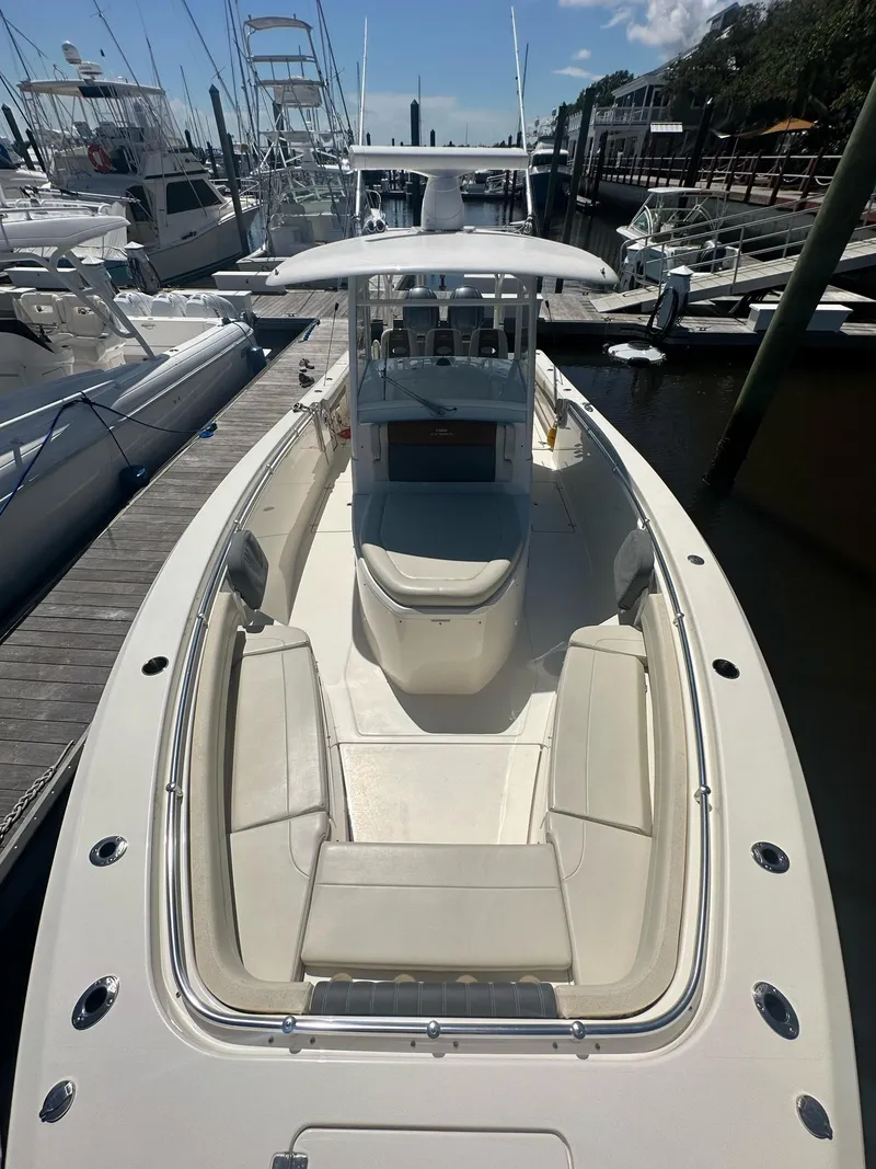 Slide: The Image of 2022 Cobia 350 Center Console boat docked, showcasing spacious seating and sleek design. - 6